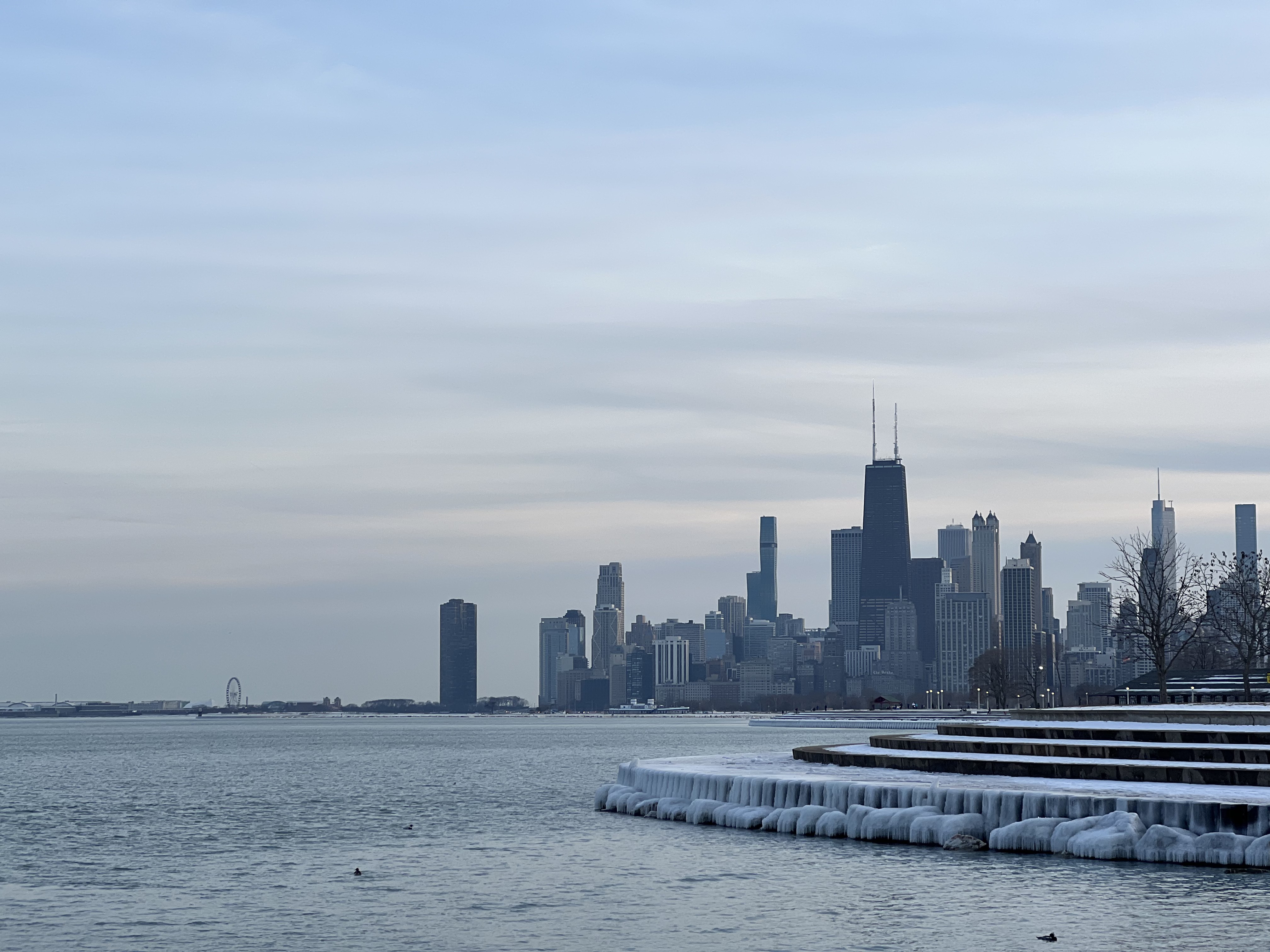 Chicago skyline over Lake Michigan with ice draped over the concrete shoreline